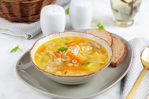 frisch Hähnchen Suppe mit Gemüse und stellin Pasta im ein Schüssel mit Karotte und Petersilie. foto