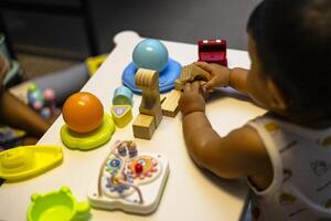 Baby spielen ein hölzern Block foto