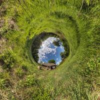 Blue Hole Sphäre kleiner Planet innerhalb des runden Rahmenhintergrunds des grünen Grases foto