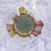 winzig Planet im Blau Himmel mit Wolken im Stadt Center in der Nähe von modern Wolkenkratzer. Transformation von kugelförmig 360 Panorama im abstrakt Antenne Sicht. foto