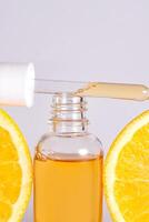 Vitamin c Serum im kosmetisch Flasche mit Orange Zitrusfrüchte Scheiben mit auf Weiß Hintergrund. Zitrusfrüchte wesentlich Öl, Kosmetika Aromatherapie. organisch Spa Kosmetika mit Kräuter- Zutaten foto