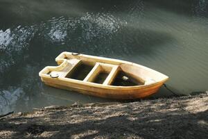 alt Gelb Plastik Boot auf das Fluss foto