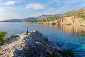 ein Frau tragen ein Hut bewundert das Strand Malo Zarace im das adriatic Küste auf hvar Insel, Kroatien. Reise und Sommer- Ferien Konzept. foto