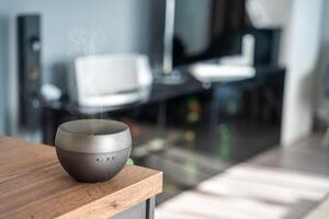 grau Aroma Öl Diffusor auf Licht Tabelle beim heim, Raum zum Text. Luft Erfrischer foto