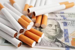 Zigarette auf uns Dollar Banknoten, kosten, Handel, Marketing und Produktion, Nein Rauchen Konzept. foto