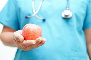 asiatisch Ernährungsberater halten Apfel gesund Essen zum geduldig im Krankenhaus, Ernährung und Vitamin. foto