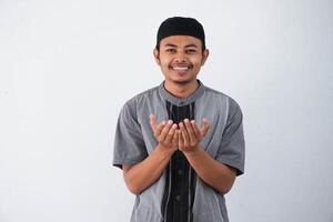 religiös jung asiatisch Muslim Mann mit öffnen Augen beten, halten Palmen Gesicht hoch, Flüstern beten, isoliert auf Weiß Hintergrund. Religion Islam, glauben Konzept foto