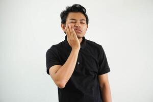 gut aussehend jung asiatisch Mann tragen schwarz Polo t Hemd berühren Mund mit Hand mit schmerzlich Ausdruck weil von Zahnschmerzen oder Dental Krankheit auf Zähne. Zahnarzt foto