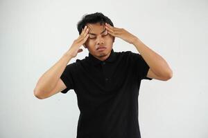 Porträt von jung asiatisch Mann isoliert auf Weiß Hintergrund Leiden von stark Kopfschmerzen, drücken Finger zu Tempel, Schließen Augen zu lindern Schmerzen mit hilflos Gesicht Ausdruck foto