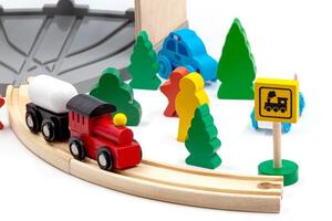 Kinder- Spielzeug Zug mit zwei Autos auf ein hölzern Eisenbahn. Bäume und Grün Weihnachten Bäume mit Menschen und Zeichen Komplett das Spielzeug Welt. zum Kinder- spielen. Weiß Hintergrund. hoch Qualität Foto. foto