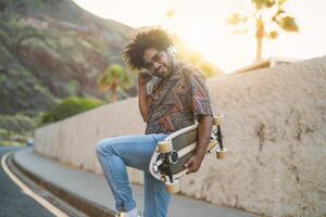 glücklich afro Mann haben Spaß Tanzen und Hören zu Musik- mit kabellos Kopfhörer während Sommer- Zeit - - Jugend Menschen Lebensstil Konzept foto