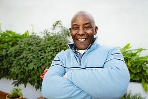 glücklich Senior afrikanisch Mann Gartenarbeit beim Zuhause foto