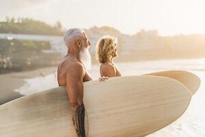 glücklich passen Surfer mit anders Alter haben Spaß Surfen auf tropisch Strand - - extrem Sport Lebensstil und Freundschaft Konzept foto