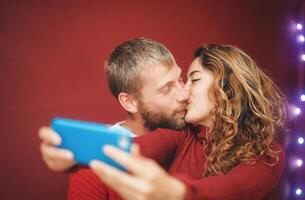 glücklich Paar Herstellung ein Selfie mit Handy, Mobiltelefon Smartphone App - - jung Liebhaber haben Spaß nehmen Selfie mit Telefon Kamera - - Beziehung, Liebe und Technologie Trends Konzept foto