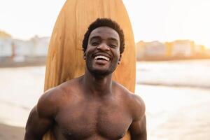 glücklich afro Surfer haben Spaß Surfen während Sonnenuntergang Zeit - - afrikanisch Mann genießen Surfen Tag - - extrem Sport Lebensstil Menschen Konzept foto