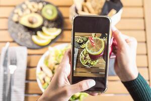 oben Aussicht weiblich Hände nehmen Foto mit Handy, Mobiltelefon Smartphone auf Gesundheit Mittagessen Essen - - jung Person haben Spaß mit Neu Technologie Apps zum Sozial Medien - - gesund Menschen Lebensstil und Technik süchtig Konzept