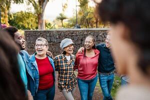 glücklich Mehrgenerationenhaus Gruppe von Menschen mit anders Ethnien haben Spaß im ein Öffentlichkeit Park - - Menschen Vielfalt Konzept foto