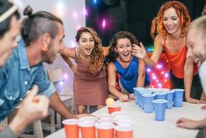 Gruppe von glücklich freunde spielen Bier Pong im Kneipe Cocktail Bar - - jung Millennials Menschen haben Spaß tun Party Alkohol Spiele beim Nacht - - Freundschaft und Jugend Lebensstil Nachtleben Konzept foto