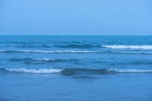 Wellen auf das Strand. Blau Meer Welle. Blau Wasser Oberfläche Textur mit Wellen, Spritzer, und Blasen. abstrakt Sommer- Banner Hintergrund Wasser Wellen im Sonnenlicht mit Kopieren Raum kosmetisch Feuchtigkeitscreme. foto