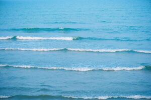 Wellen auf das Strand. Blau Meer Welle. Blau Wasser Oberfläche Textur mit Wellen, Spritzer, und Blasen. abstrakt Sommer- Banner Hintergrund Wasser Wellen im Sonnenlicht mit Kopieren Raum kosmetisch Feuchtigkeitscreme. foto