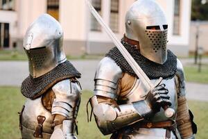 zwei Ritter im Rüstung auf das Hintergrund von ein mittelalterlich Schloss.a mittelalterlich Konzept.metallisch Textur foto