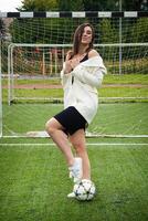 Porträt von ein schön Frau Fußball Spieler im ein streng Büro Anzug. foto