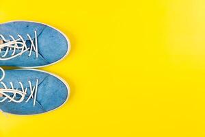 Blau Schuhe Stand auf ein isoliert Gelb Hintergrund foto