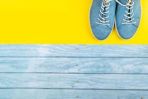 das Blau Schuhe Stand auf ein isoliert gemischt Blau und Gelb Hintergrund foto
