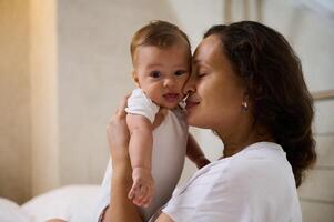 herrlich Mutter genießt glücklich Momente mit ihr Baby Junge, kuscheln ihn. Liebe. Zärtlichkeit. glücklich Mutter Tag Konzept foto