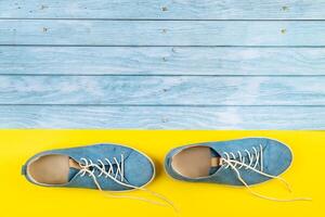das Blau Schuhe Stand auf ein isoliert gemischt Blau und Gelb Hintergrund foto