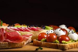 sortiert Sandwiches mit Fisch, Käse, Fleisch und Gemüse Lügen auf das Tafel foto