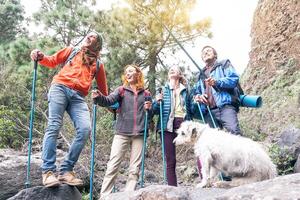 Gruppe von freunde mit Rucksäcke tun Trekking Ausflug auf Berg mit ihr Haustier - - jung Touristen Gehen und erkunden das wild Natur - - Wanderer, Wanderung und Reise Menschen Konzept foto