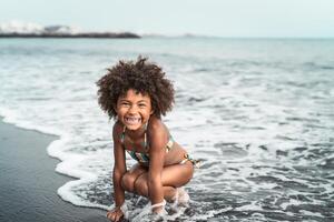 afro amerikanisch Kind haben Spaß auf das Strand - - wenig Kind spielen während Sommer- Zeit draussen - - schwarz Menschen und Ferien Konzept foto