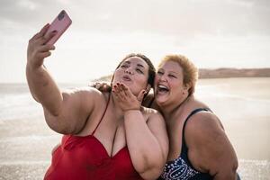 glücklich Plus Größe Frauen nehmen Selfie mit Handy, Mobiltelefon Smartphone auf das Strand - - Übergewicht freunde haben Spaß während Ferien Zeit foto