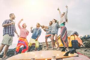 glücklich freunde Tanzen und haben Spaß Herstellung ein Strand Party im das Campingplatz - - jung Menschen Lachen und Trinken Biere während Camping Nächster Ozean - - reisen, Urlaub, Lebensstil Konzept foto