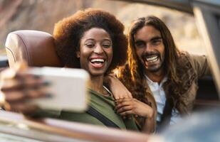 glücklich jung Paar nehmen Selfie mit Handy, Mobiltelefon Smartphone während tun Straße Ausflug - - Reise Menschen haben Spaß Fahren im Cabrio Auto entdecken Neu setzt - - Beziehung und Ferien Lebensstil Konzept foto