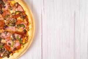 köstlich groß Pizza mit Kalbfleisch und Pilze auf ein Licht hölzern Hintergrund foto