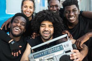 glücklich Gruppe von gemischtrassig Menschen haben Spaß Hören Musik- mit Jahrgang Boombox draussen - - Jugend Menschen Lebensstil foto