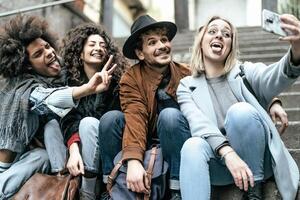 jung gemischtrassig Gruppe von freunde nehmen Selfie mit Handy, Mobiltelefon Smartphone Sitzung auf städtisch Treppe - - Jugend tausendjährig Lebensstil Konzept foto
