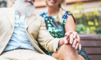 glücklich Senior Paar haben ein romantisch Moment draussen - - reifen elegant Menschen Ausgaben Zeit zusammen Sitzung auf Bank - - Liebe, Zuneigung und Alten Lebensstil Konzept foto