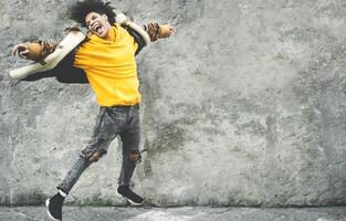 afro amerikanisch Mann haben Spaß Tanzen im Stadt Center - - glücklich jung Kerl Springen und genießen positiv Momente - - tausendjährig Generation Lebensstil und cool Menschen Einstellung Konzept foto