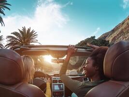 jung glücklich Frauen tun ein Straße Ausflug im tropisch Stadt - - Reise Menschen haben Spaß Fahren im modisch Cabrio Auto entdecken Neu setzt - - Freundschaft und Jugend Freundinnen Ferien Lebensstil Konzept foto