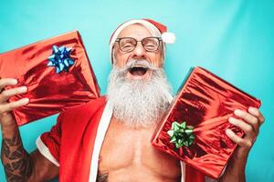 glücklich Santa claus halten Weihnachten Geschenk - - Hipster passen Senior haben Spaß feiern Weihnachten Ferien - - Alten Menschen und traditionell Lebensstil Kultur foto