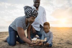 glücklich afrikanisch Familie haben Spaß auf das Strand während Sommer- Ferien - - Eltern Liebe und Einheit Konzept foto