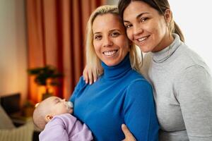 glücklich Lesben Paar mit klein Baby beim Zuhause Porträt - - lgbt Familie Konzept foto
