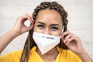 jung afro Frau mit Zöpfe tragen Gesicht medizinisch Maske Porträt - - afrikanisch Mädchen mit Schutzmaske zum verhindern und halt Corona Virus Verbreitung - - Gesundheitswesen medizinisch und Jugend tausendjährig Menschen Konzept foto