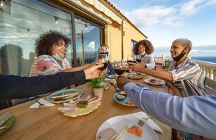 jung freunde Toasten mit rot Wein Brille beim Abendessen Vorspeise - - trinken und Essen Konzept foto