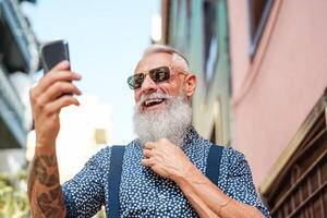 bärtig Senior mit Handy, Mobiltelefon Telefon draussen - - Hipster reifen Mann haben Spaß mit Neu Trends Smartphone Apps - - Menschen Lebensstil, Technologie und Sozial Influencer Konzept foto