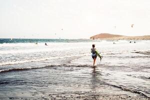 Surfer Stehen auf das Strand mit Surfbretter vorbereiten zu Surfen auf hoch Wellen - - sportlich jung Menschen haben Spaß während ein Surfen Tag - - extrem Sport, und Jugend Lebensstil konzept foto