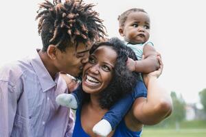 glücklich afrikanisch Familie haben Spaß zusammen im Öffentlichkeit Park - - schwarz Vater und Mutter genießen Wochenende mit ihr Tochter - - Menschen Liebe und Elternteil Einheit Konzept foto